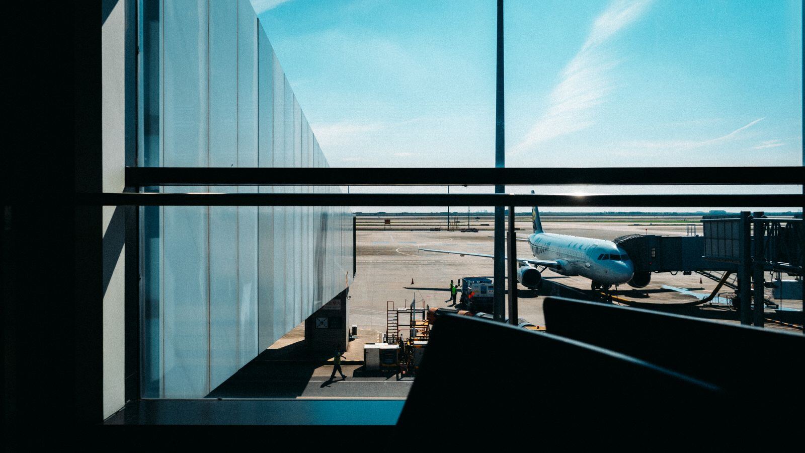Airliner at the gate seen through a terminal window