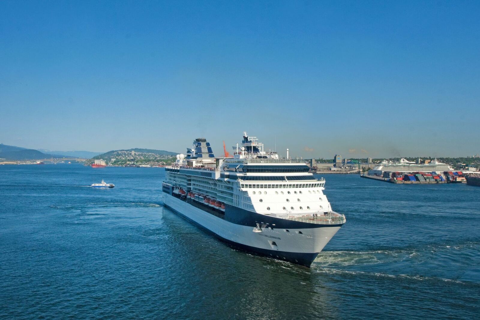 Cruise ship leaving port on calm blue water